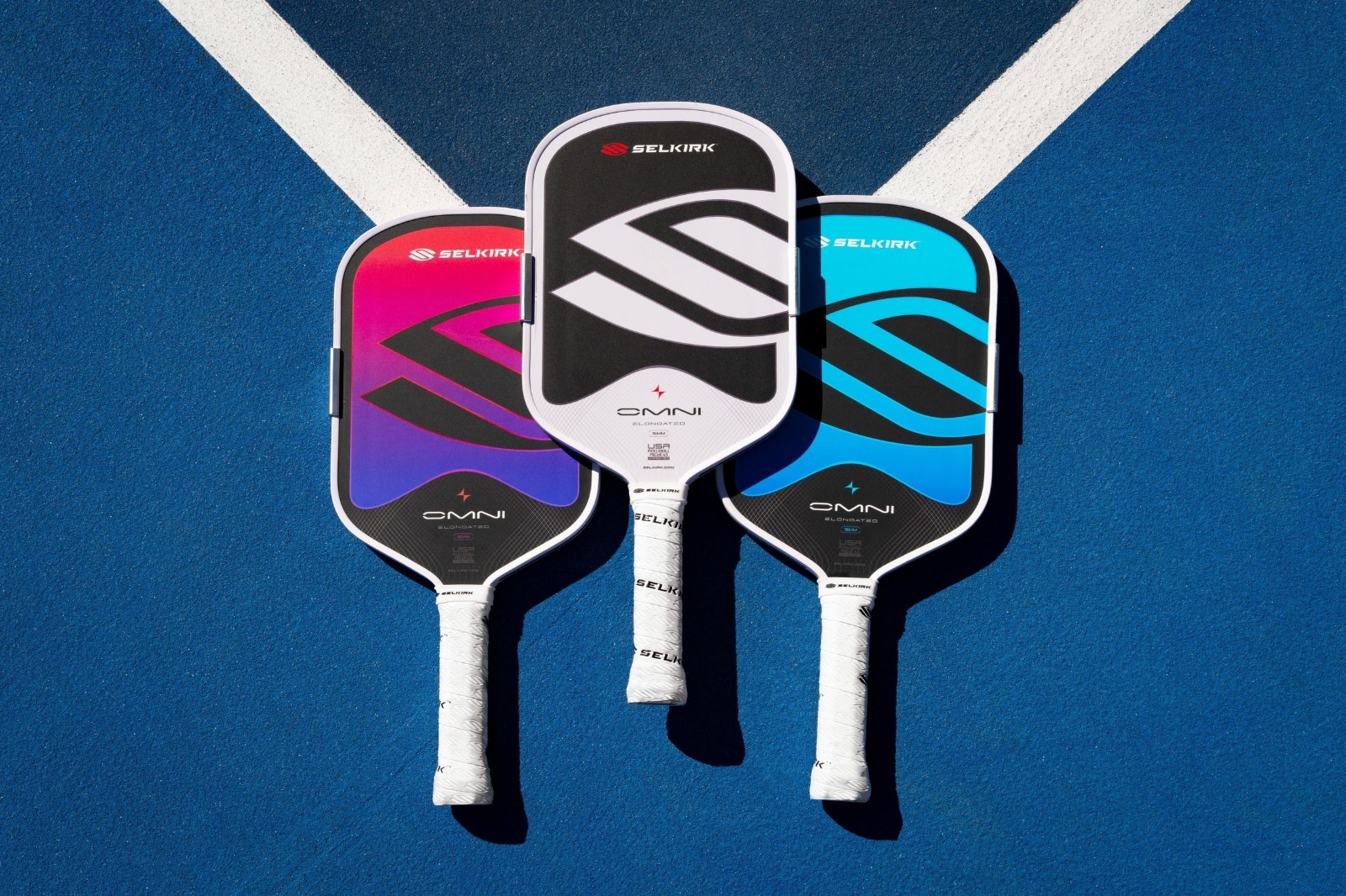 Three premium pickleball paddles on court